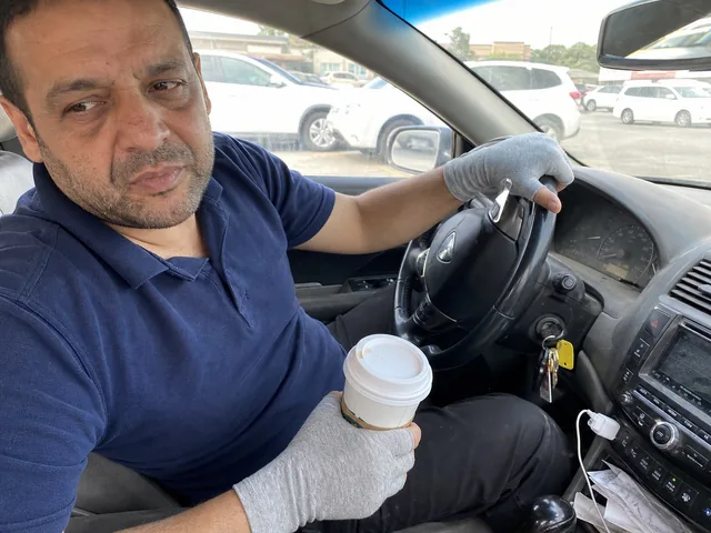 יד לובשת כפפת קומפרסיה אפורה מחזיקה כוס קפה ברכב