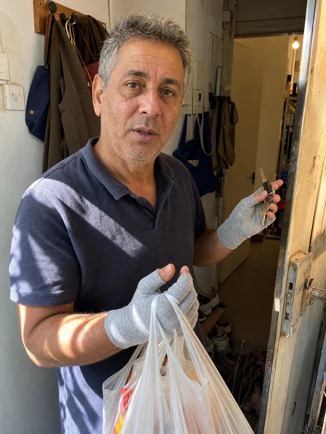 יד לובשת כפפת קומפרסיה אפורה מחזיקה מפתחות ושקיות קניות בכניסה
